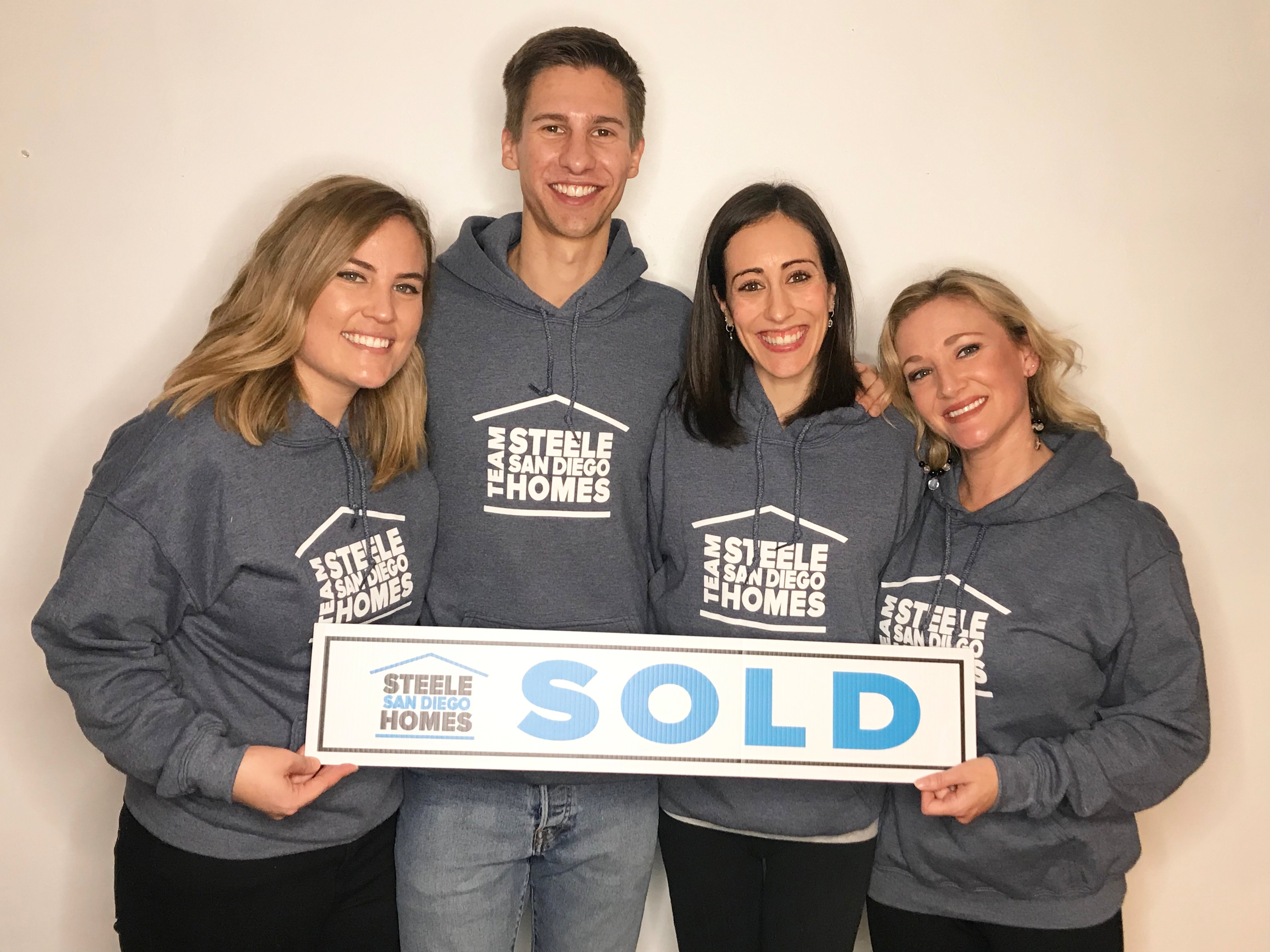 Team Steele San Diego Homes holding a SOLD sign